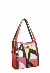 Sac à main coloré avec des anses rouges, un mélange de motifs rose, blanc et noir, des accents brillants et un charme décoratif.