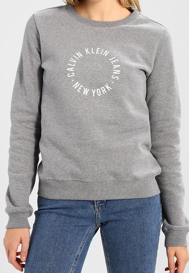Felpa grigia in misto cotone, con scollo rotondo e polsini a costine. Il testo stampato sul fronte recita "CALVIN KLEIN JEANS NEW YORK."