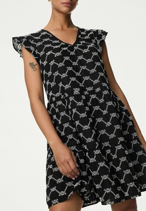 Abito nero con motivo geometrico bianco, maniche corte a arricciatura, scollo a V e gonna arricciata. Tessuto leggero con leggera texture.