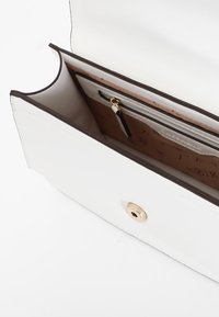 Borsa a pochette bianca, esterno texturizzato, rifinitura marrone, chiusura a scatto dorata, interno con compartimenti separati e una tasca con zip.