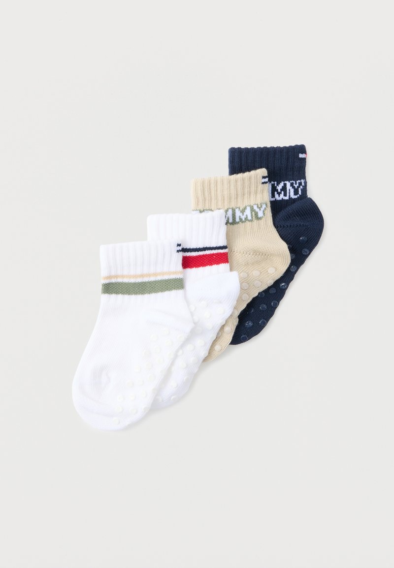 Quatre paires de chaussettes antidérapantes pour tout-petits, texturées, en blanc avec des rayures vertes et beiges, blanc avec des rayures rouges et bleu marine, beige et bleu marine.