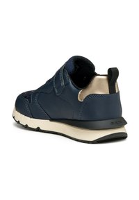 Sneaker in pelle blu navy con un accento dorato, dotato di una cinghia in velcro, dettagli texture e una suola in gomma bianca con una suola nera.