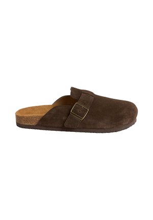 Scarpa mocassino in camoscio marrone con punta arrotondata, plantare in sughero e fibbia metallica regolabile sulla fascia superiore. Superficie strutturata e suola piatta.