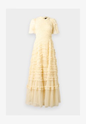 Μάξι φόρεμα σε κρεμ απόχρωση με κοντά φουσκωτά μανίκια, στρωτές βολάν και διάφανο ύφασμα με πουά λεπτομέρειες σε όλο το φόρεμα.