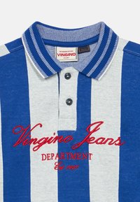 Camisa polo às riscas azuis e cinzentas com colarinho canelado, dois botões pretos e texto vermelho bordado "Vingino Jeans Department Est. 1997."