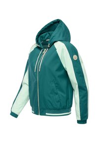 Kurtka z kapturem w kolorze morskim i jasnej mięty, z przednim zamkiem błyskawicznym, bocznymi kieszeniami, elastycznymi mankietami oraz okrągłą naszywką z logo na lewym rękawie.