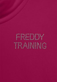 T-shirt atletico fucsia con testo "FREDDY TRAINING" in strass metallici, colletto rotondo e morbida texture del tessuto.