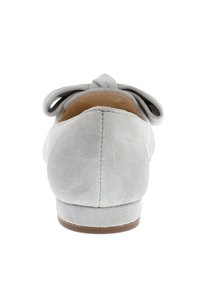 Graue Wildleder-Ballerinas mit runder Spitze, einer Schleifenapplikation hinten, niedrigem Absatz und glattem Innenfutter. Die Sohle ist hellbraun.