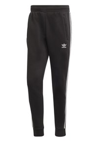 Svarta Adidas träningbyxor med vita sidostrep, ribbade ankle cuffs, elastisk midja och Adidas-logotyp på vänstra låret.