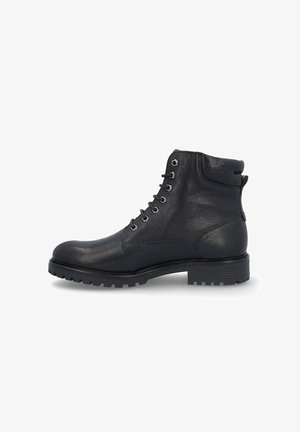 Bota de cuero negro hasta el tobillo con acabado texturizado, diseño de cordones, ojales de metal y una suela de goma gruesa para agarre y durabilidad.