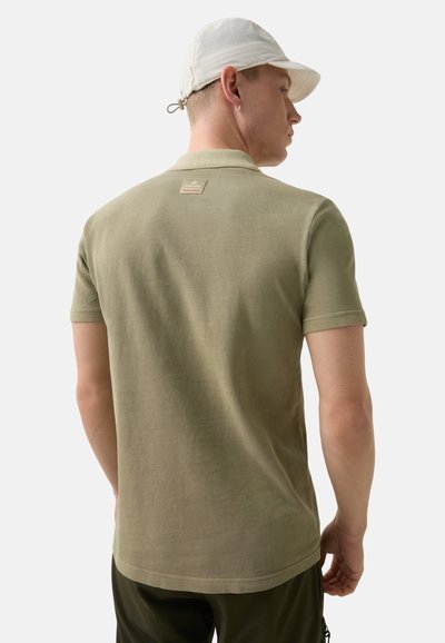 Olive green short-sleeve polo shirt with a rounded hem, featuring a textured finish and a woven label at the back neckline.