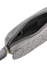 Šedý tkaný kožený sáček s hladkým, plochým vrškem, zapínáním na zip a vnitřní kapsou, vystavující texturovaný povrch a jemnou fialovou podšívku.