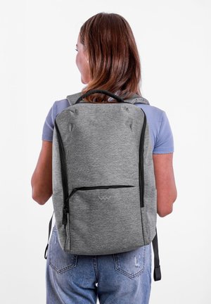 Grau gefärbter Stoff-Rucksack mit schwarzen Reißverschlüssen, rechteckiger Form, glatter Textur, ausgestattet mit einer Fronttasche und ergonomischen Tragegurten.