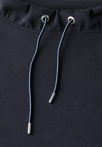 Marineblauer Sweatshirtstoff mit einem gerafften Ausschnitt, der zwei blaue Kordeln mit silbernen Metall-Enden und Ösen zur Anpassung enthält.