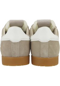 Baskets en daim beige avec des accents en cuir blanc et des semelles en caoutchouc tan. Comprend un col rembourré et une texture lisse. Vue de l'arrière.