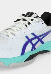 Λευκό και μαύρο αθλητικό παπούτσι Asics με μπλε λογότυπο, λευκά κορδόνια, τιρκουάζ ενδιάμεση σόλα και υφασμένη λαστιχένια εξωτερική σόλα.