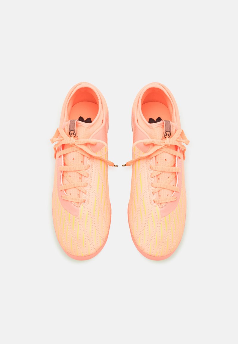 Zapatillas deportivas en un brillante color coral con un upper texturizado, que presenta patrones de olas amarillos, ojales reforzados y cordones tradicionales.