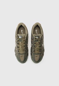 Nike tenisice s gornjim dijelom od mrežaste tkanine i kože u maslinastoj boji, s teksturiranim uzorkom, debljim vezicama i bijelim logotipom na jeziku.