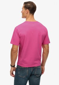 Kortærmet T-shirt i lys pink, lavet af blød bomuld. Har en klassisk rund halsudskæring og en afslappet pasform. Minimalistisk design uden mønstre.