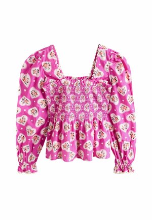 Roze blouse met smock en pofmouwen, versierd met hartvormige bloemenpatronen en stippen. Textiel met textuur en gerimpelde details.