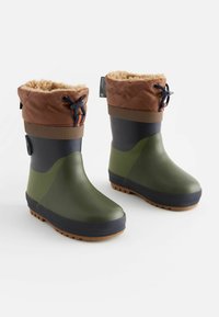 Bottes en caoutchouc vertes avec un revers matelassé marron, des accents bleu marine et une semelle texturée présentant un motif de crampons pour une meilleure adhérence.