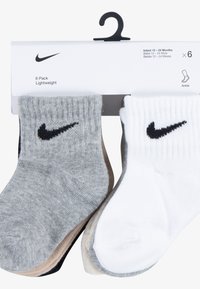Seks-pakning med lette ankelstrømper i grå, hvit og beige. Hver har en ribbet mansjett og en svart Nike-swoosh-logo. Passer for spedbarn fra 12 til 24 måneder.
