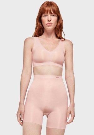 Bralette sans coutures rose clair avec un décolleté en V et un short taille haute assorti. Texture lisse et design minimaliste, marque 'gisela.'