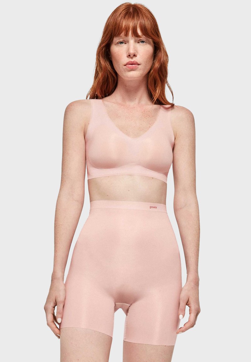Hellrosa nahtlose Bralette mit V-Ausschnitt und passenden hochtaillierten Shorts. Glatte Textur und minimalistisches Design, Marke 'gisela'.