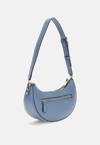 Blauwe leren tas met een gebogen vorm, verstelbare schouderriem en één ritsvak aan de voorkant. Gladde textuur en zilveren hardware accenten.