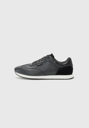 Black athletic sneakers featuring a leather upper with perforated detailing, suede accents, and a white rubber sole. Classic lace-up design.