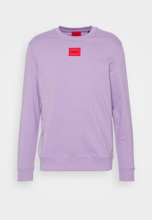 Sudadera lila con cuello redondo, mangas largas, puños y dobladillo acanalados, con un parche de logo cuadrado rojo en el pecho. Textura suave.