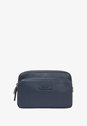 Marineblauw leren reistas met twee ritsvakken, gladde textuur en een subtiel geperst logo aan de voorkant.