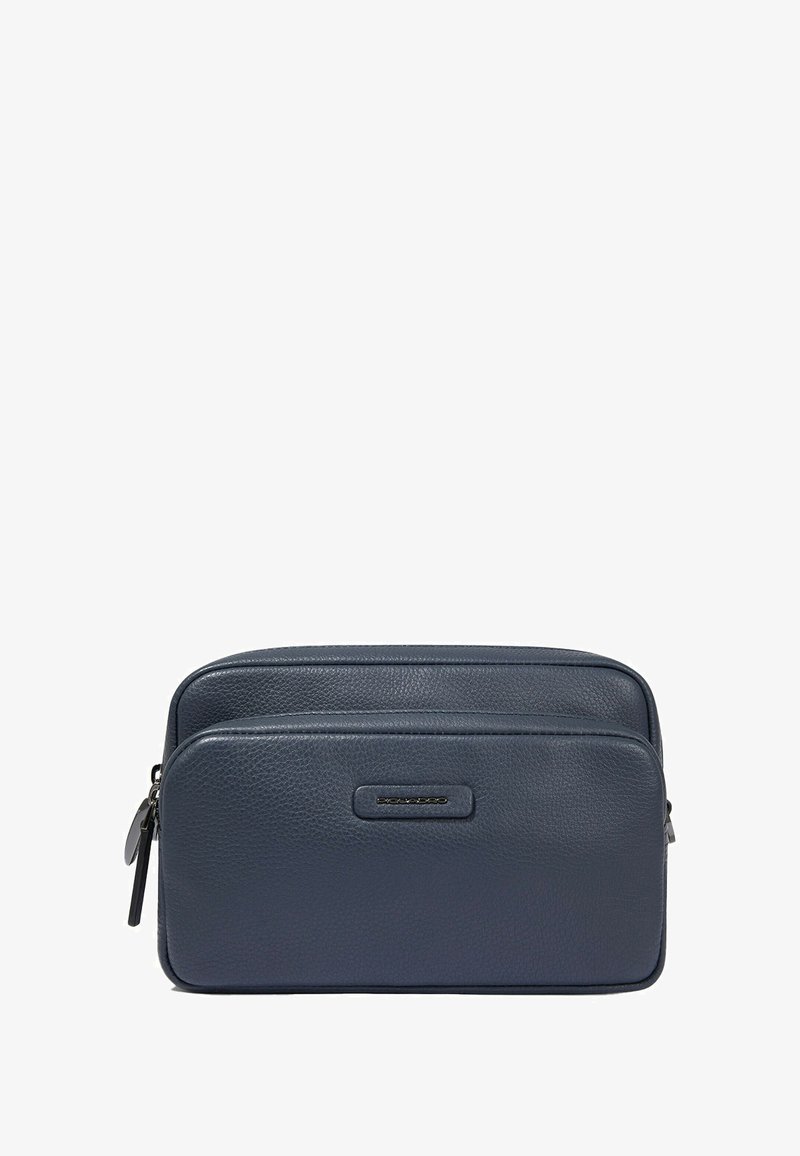 Marineblauw leren reistas met twee ritsvakken, gladde textuur en een subtiel geperst logo aan de voorkant.