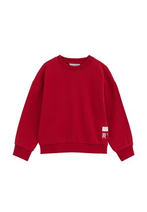 Pull sweatshirt rouge à manches longues avec col rond, poignets et ourlet côtelés, comportant deux petites étiquettes blanches près du bas côté droit.