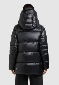 Chaqueta negra acolchada con superficie brillante y diseño acolchado, capucha grande y parche con logo en la parte trasera. Cuenta con mangas largas y dobladillo corto.