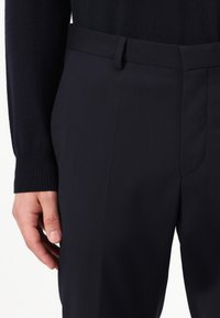 Dark navy tailored trousers with a smooth texture, featuring a flat front, side pocket, and a clean waistband design.