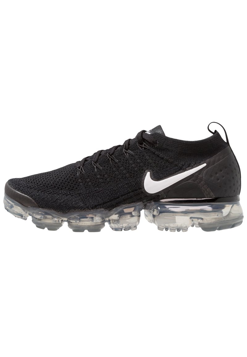 Chaussure de sport noire avec tige en maille, semelle transparente et logo Nike en blanc. Le design comprend des motifs texturés et un col ressemblant à une chaussette.