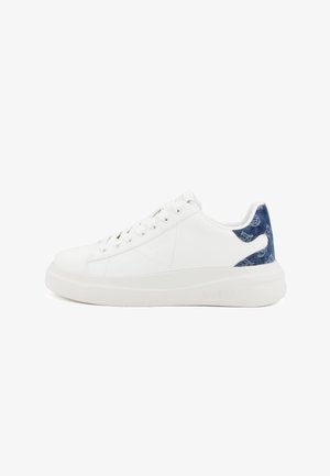 Sneaker bianco basso con lacci bianchi, suola spessa e un tallone in denim blu con un motivo.