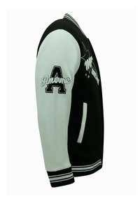 Zwart-witte varsityjack met geborduurde accenten, geribde mouwen en kraag, zijzakken en contrasterend mouwontwerp.