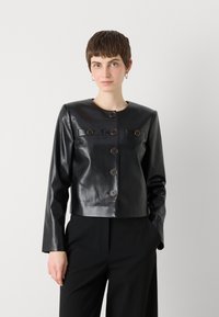 Black leather cropped jacket with a round neckline, six brown buttons, and two front pockets with flaps. Smooth texture and fitted design.