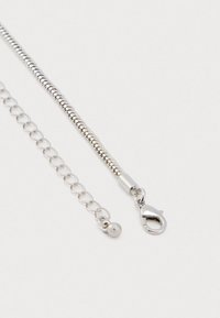 Collier en chaîne serpentine argentée avec fermoir à lobster et chaîne ajustable avec une petite perle ronde à l'extrémité sur fond blanc.