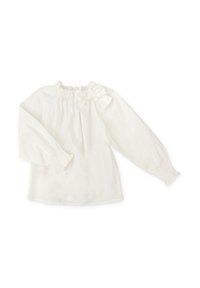 Blusa blanca con cuello fruncido, mangas largas con puños elásticos y un lazo decorativo en la parte delantera. Textura de tela suave.