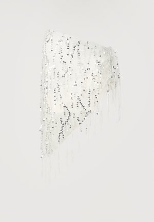 Fehér háromszög alakú szövet, amely csillogó ezüst flitterekkel és vékony rojtokkal díszített egy egyszínű háttér előtt.