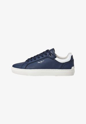 Marineblauwe sneaker met een glad leren bovenkant, witte accenten op de kraag en zool, en een platte vetersluiting. Heeft logodetails aan de zijkant.