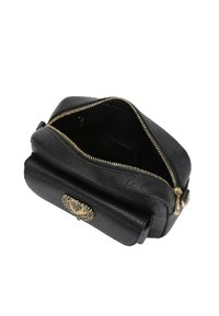 Borsa nera in pelle con zip dorata, caratterizzata da un esterno texturizzato e un accento decorativo dorato sulla parte frontale. La vista dall'alto mostra l'interno.