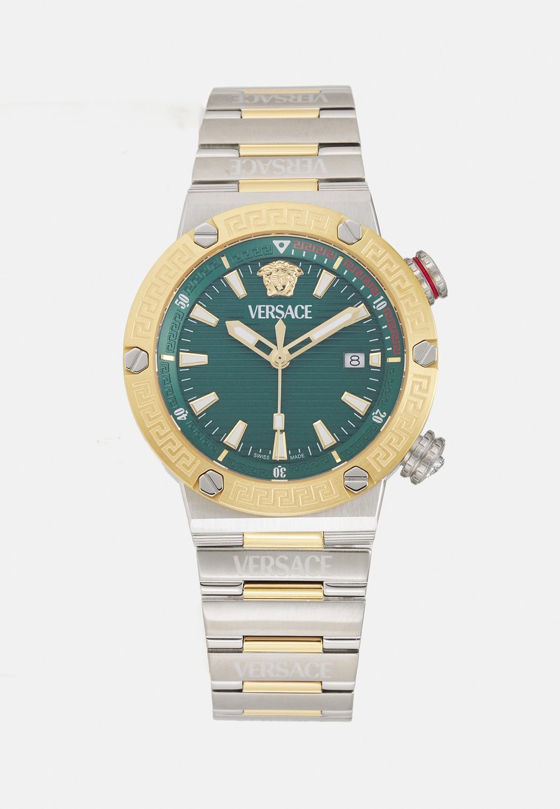 Versace pulksteņi ar zaļu teksturētu ciparnīcu, zelta rāmi un sudraba siksnu. Iespējas ietver lauvas simbolu, datuma rādījumu un izteiksmīgus stundu marķierus.