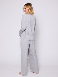 Conjunto de ropa de casa en gris claro con mangas largas, pantalones sueltos, material de algodón, sutil ribete blanco y un ajuste relajado, visto desde la parte trasera.