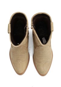 Stivaletti alla caviglia in suede marrone chiaro con punta affusolata, cuciture decorative e chiusura con zip laterale. Fodera interna liscia e suola testurizzata.