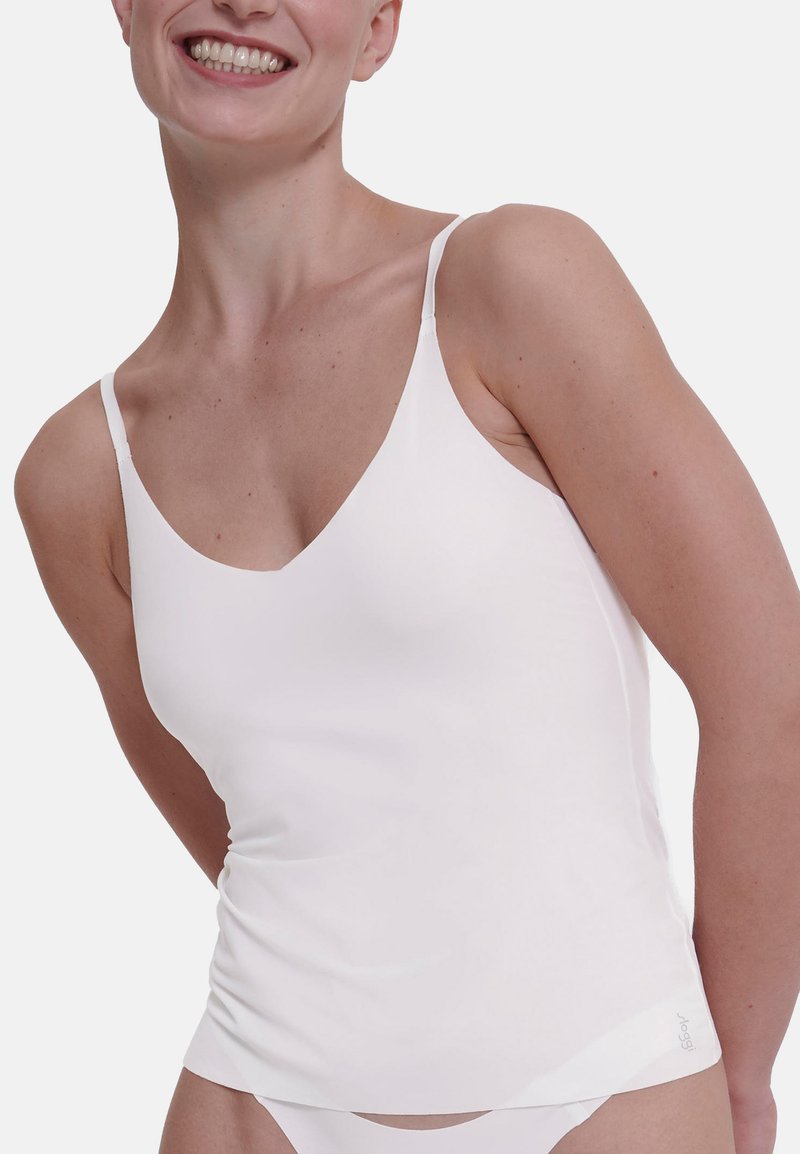 White camisole with thin straps, made of smooth fabric. Features a V-neckline, fitted design, and gathers at the waist for a subtle texture.