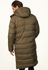 Olivgrüne Steppjacke mit Kapuze. Verfügt über ein gesteppte Design, mittlere Länge und elastische Bündchen. Glatte, glänzende Textur.